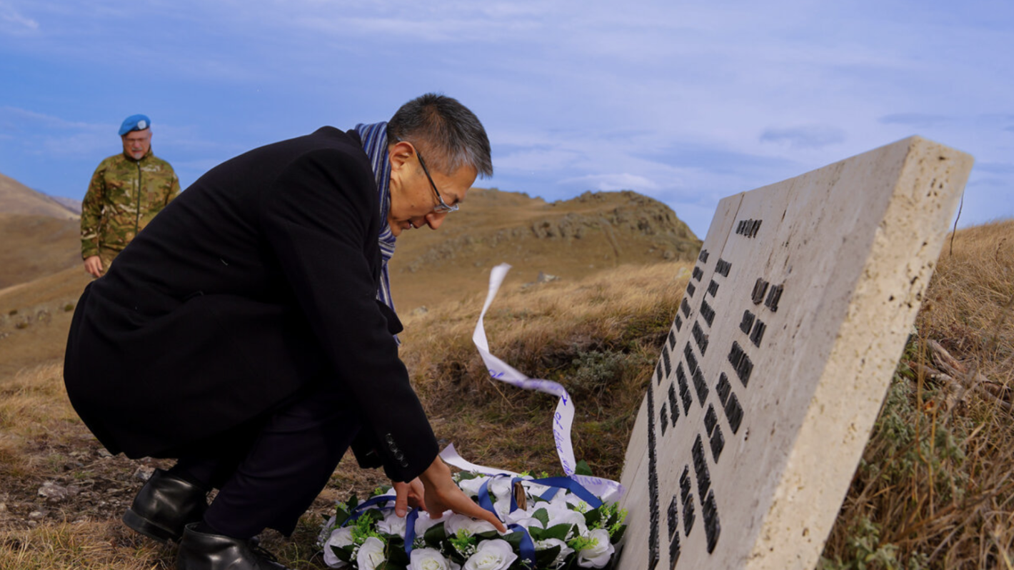 Man placing flowers on grave