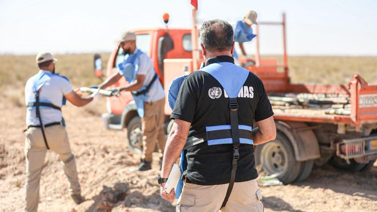 the back of man wearing black T-shirt walking towards a truck