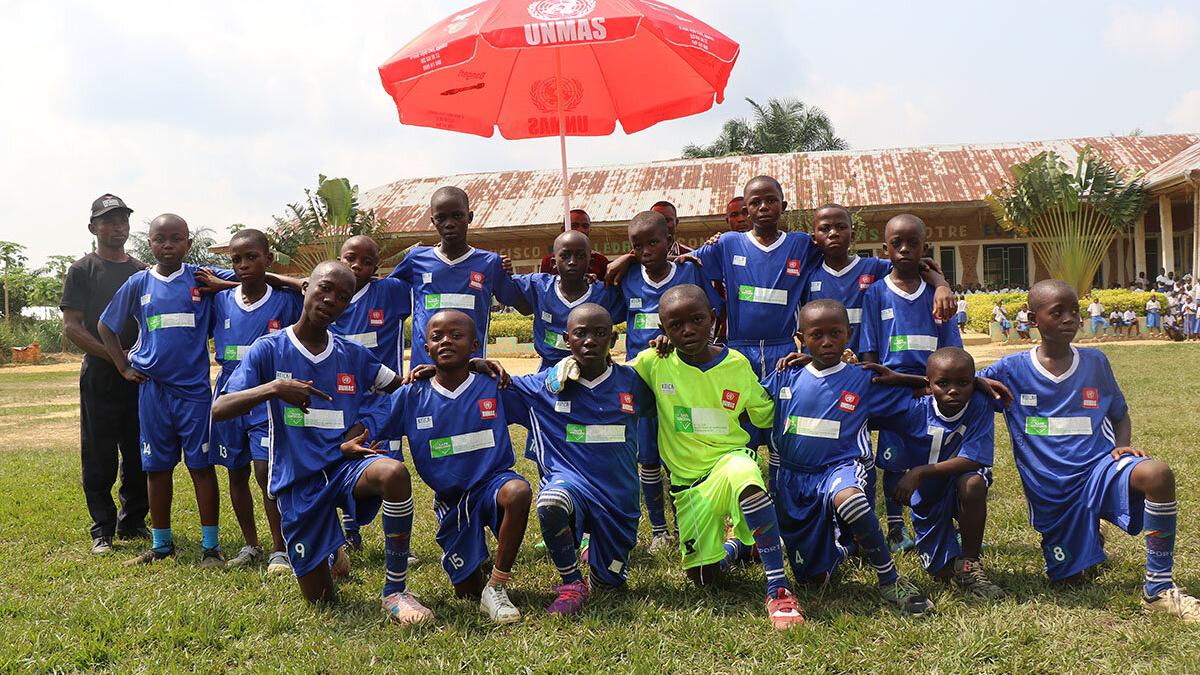 a boy football team under a red umbrella