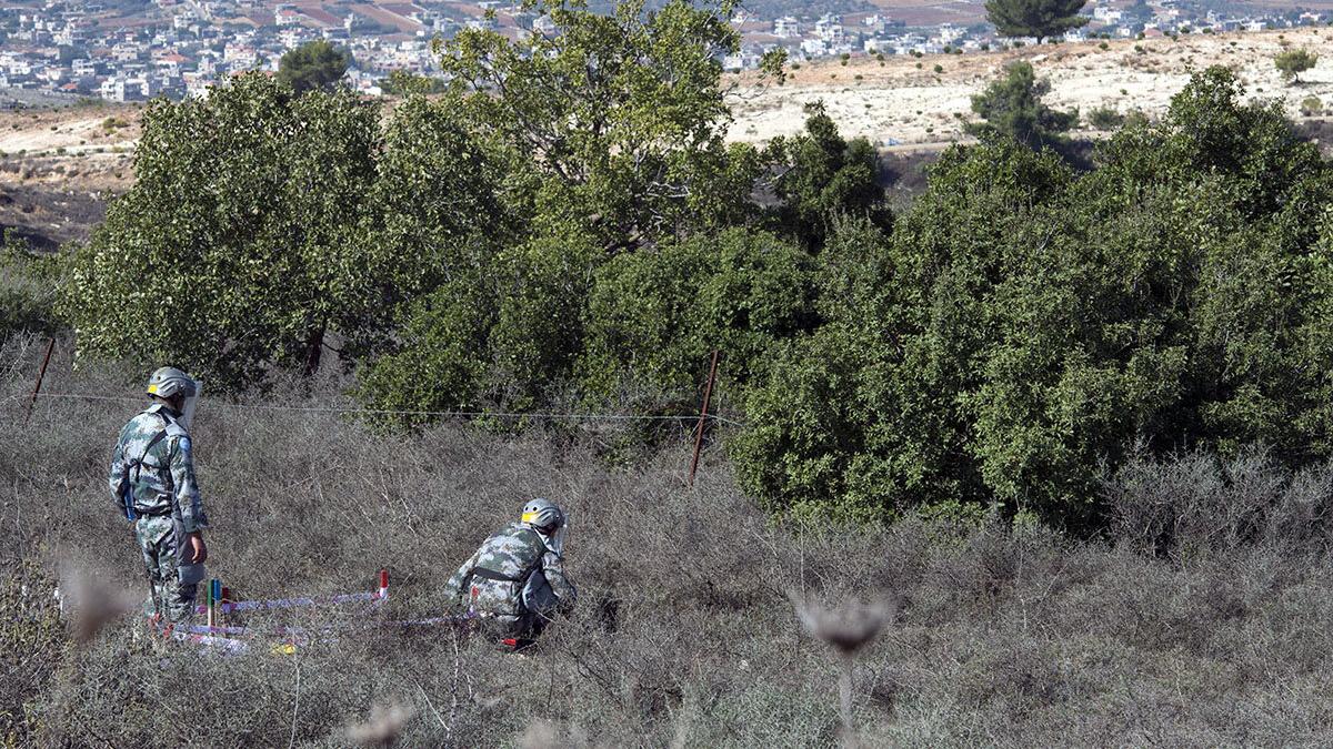 A deminer pauses as he checks the ground in front of him along the Blue Line in the vicinity of Rmeish, south Lebanon.