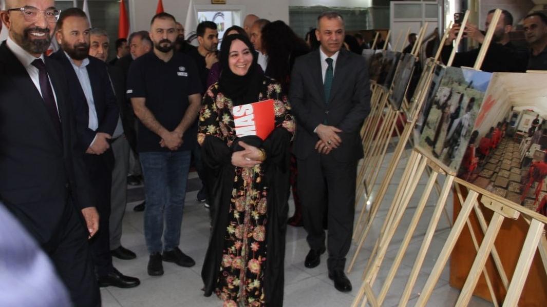 people walking with pictures on a stand besode them