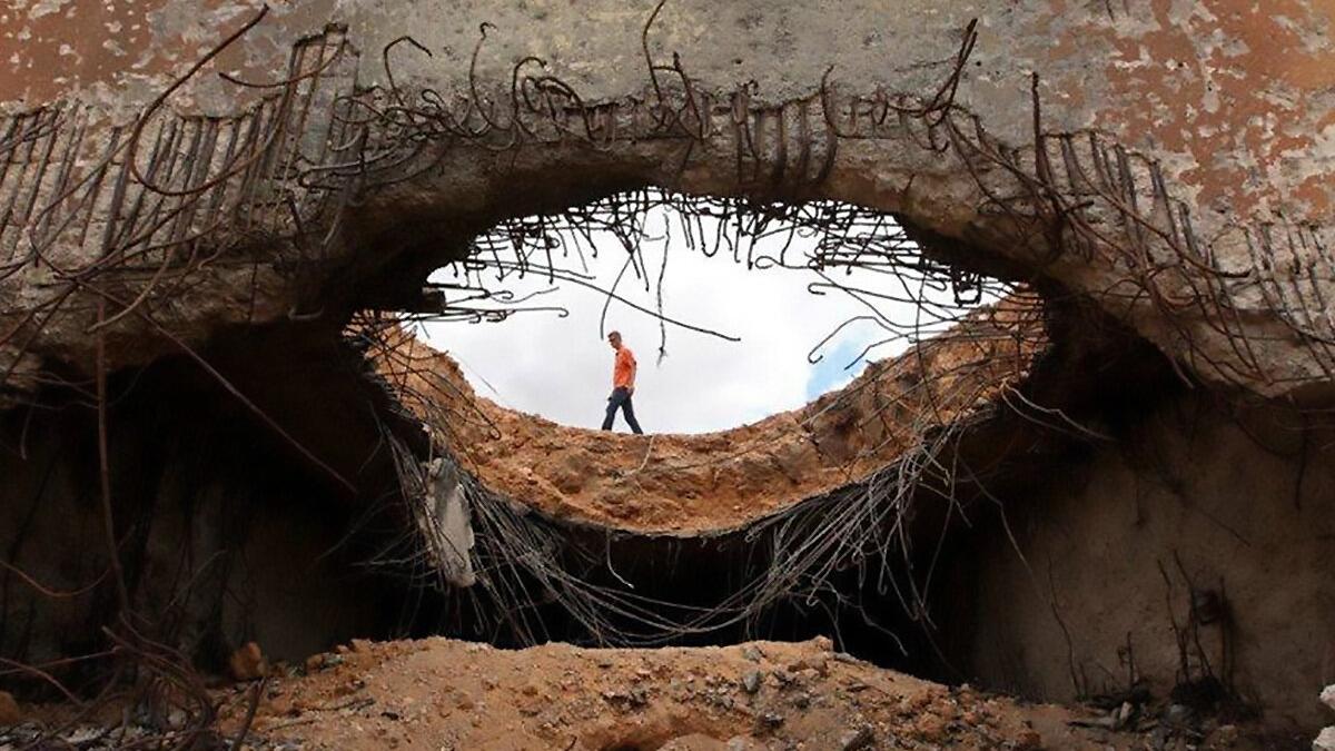 Mine action expert investigates a destroyed bunker within an ammunition storage area in Misrata, Libya.