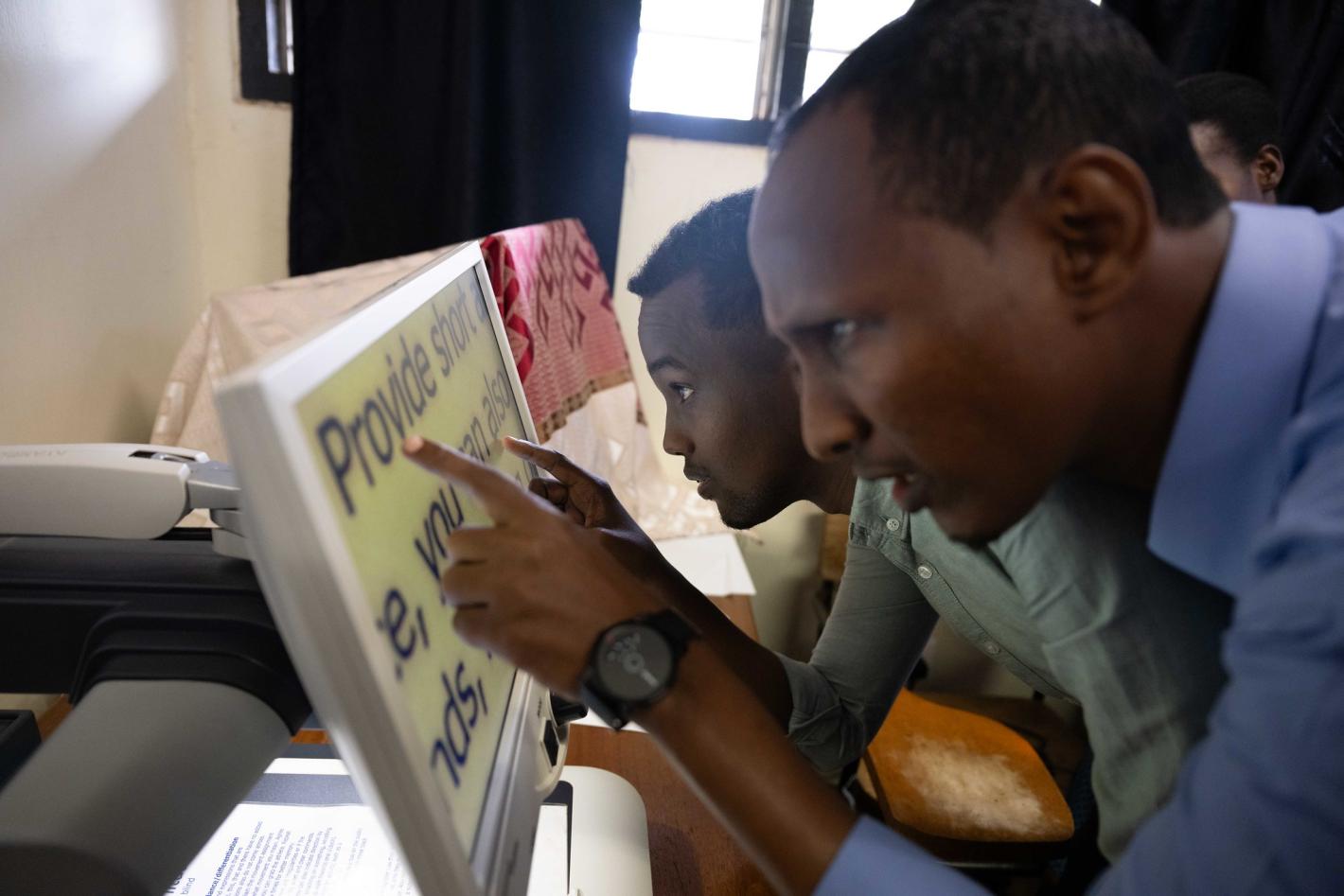 A photo of Abdulkadir Mohamed Abdullahi and Abdirahman Mohamud Kulane, take part in a visual exercise during a week-long training on braille production and digital inclusion at KyU Hi-Techn Center in Kampala, Uganda.
