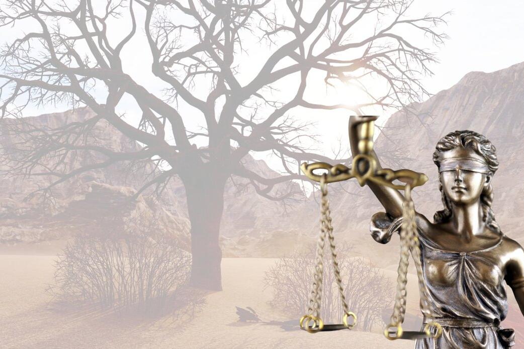 The symbol of Justice with an image of the desert in the background
