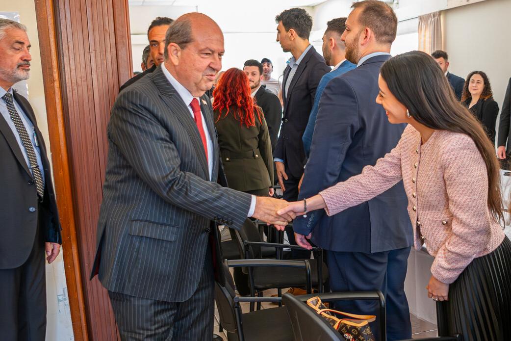 The Turkish Cypriot leader, Ersin Tatar, shakes his hand.