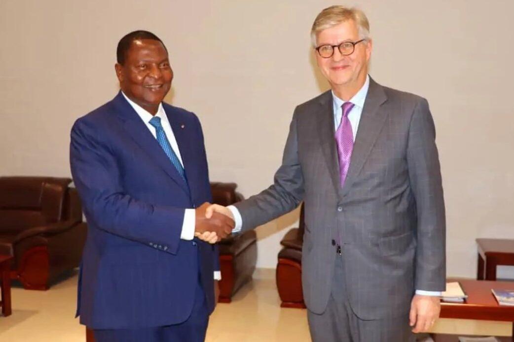 Deux hommes en costume se serrent la main.