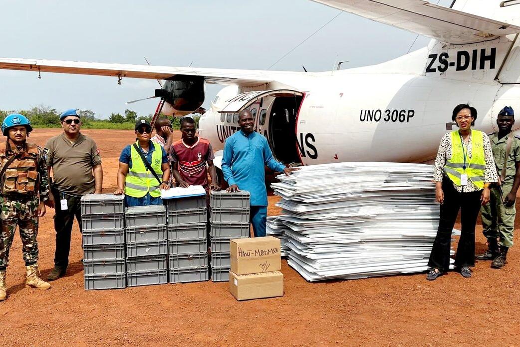 Des Casques bleus de la MINUSCA se tiennent au sol à côté d'un avion de l'ONU