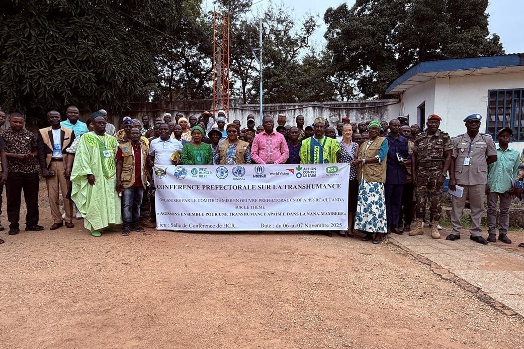 Des représentants se tiennent derrière une bannière commémorative.
