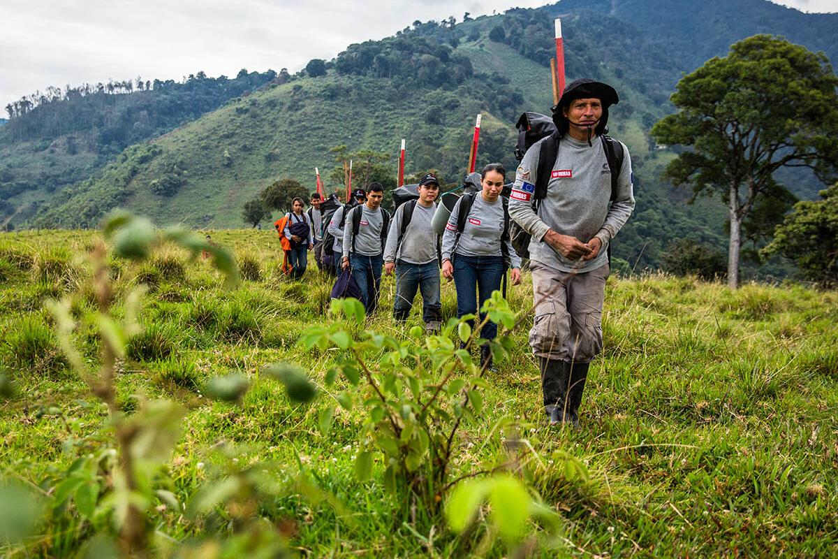 a group of man walking in line in a field