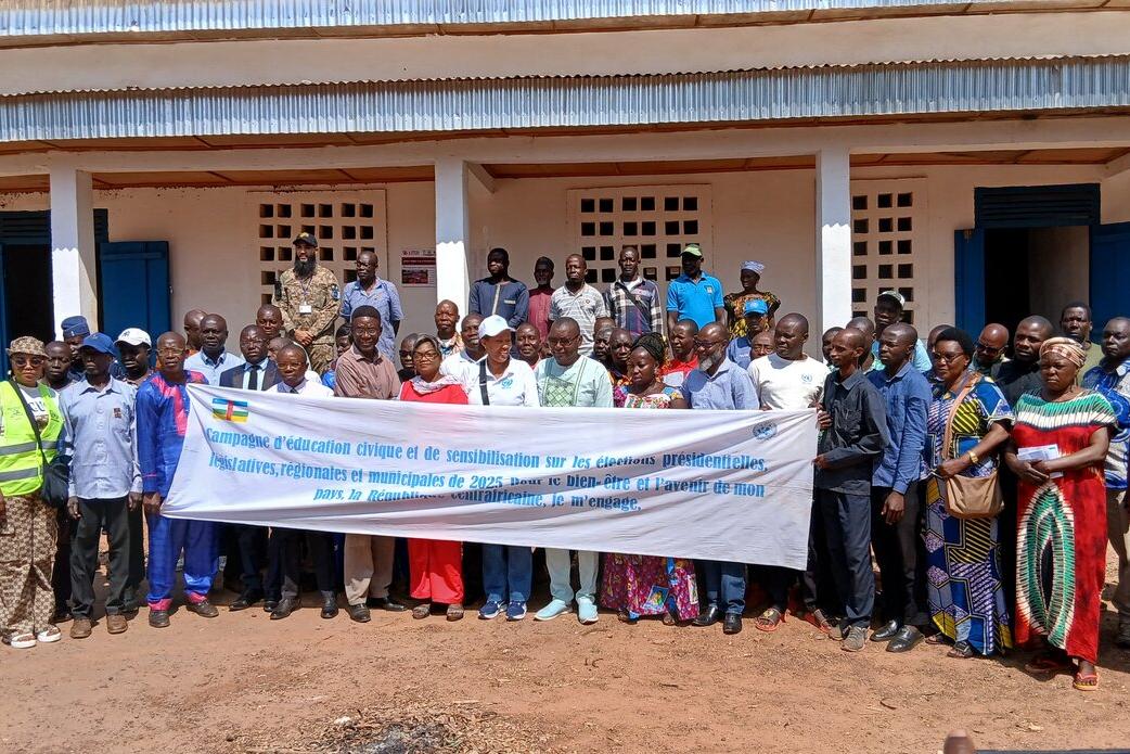 Un groupe de représentants tient une bannière en posant pour une photo commémorative.