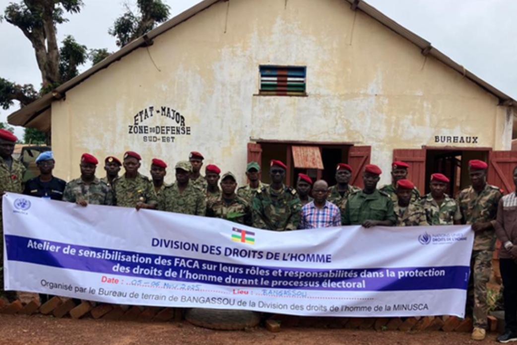 Les soldats de la paix tiennent une banderole avec le texte « Division des Droits de l'Homme ».