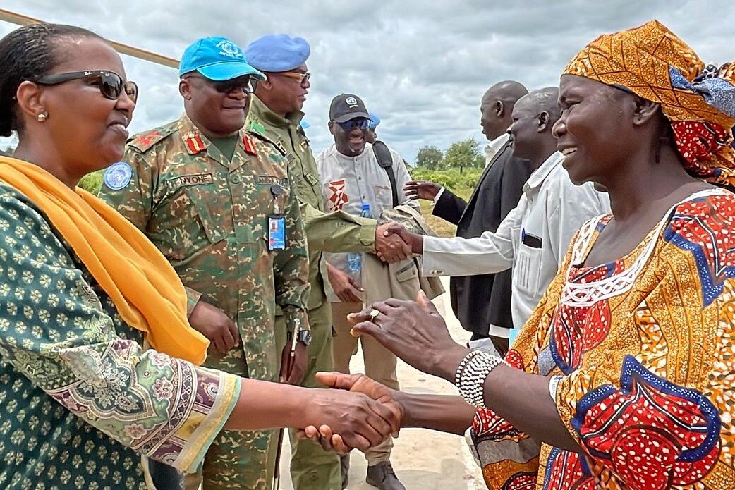 Valentine Rugwabiza et des casques bleus serrent la main de représentants.