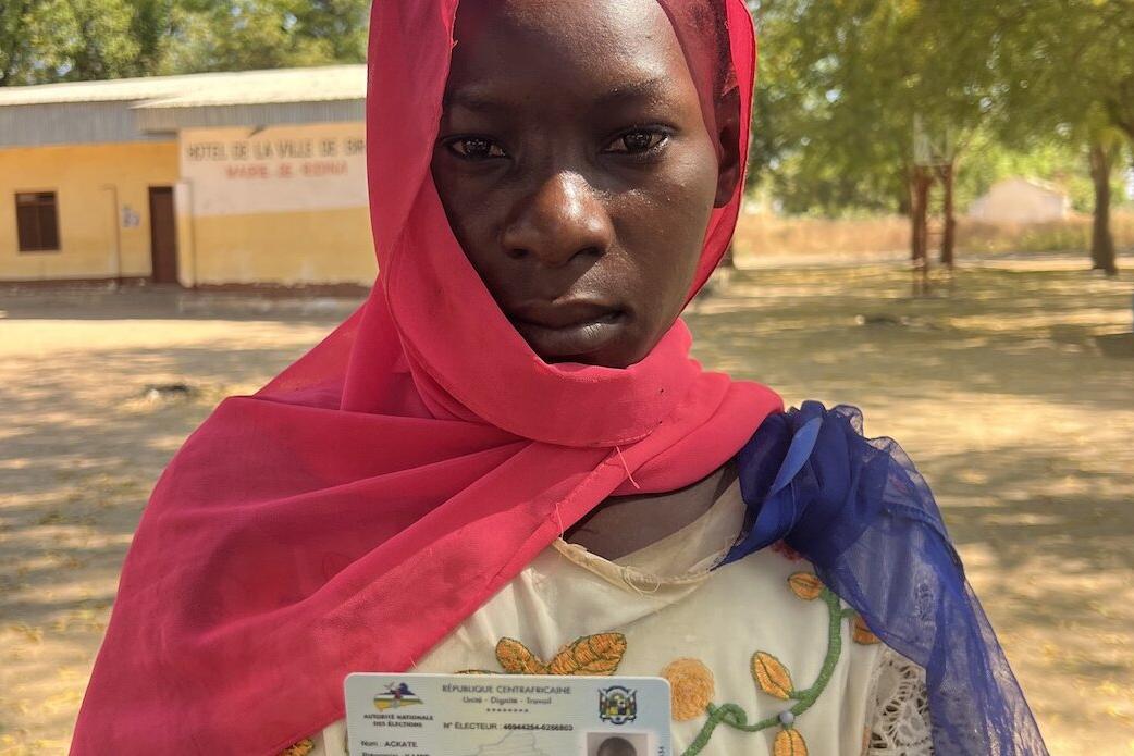 Un électeur pose pour une photo avec sa carte d’identité.