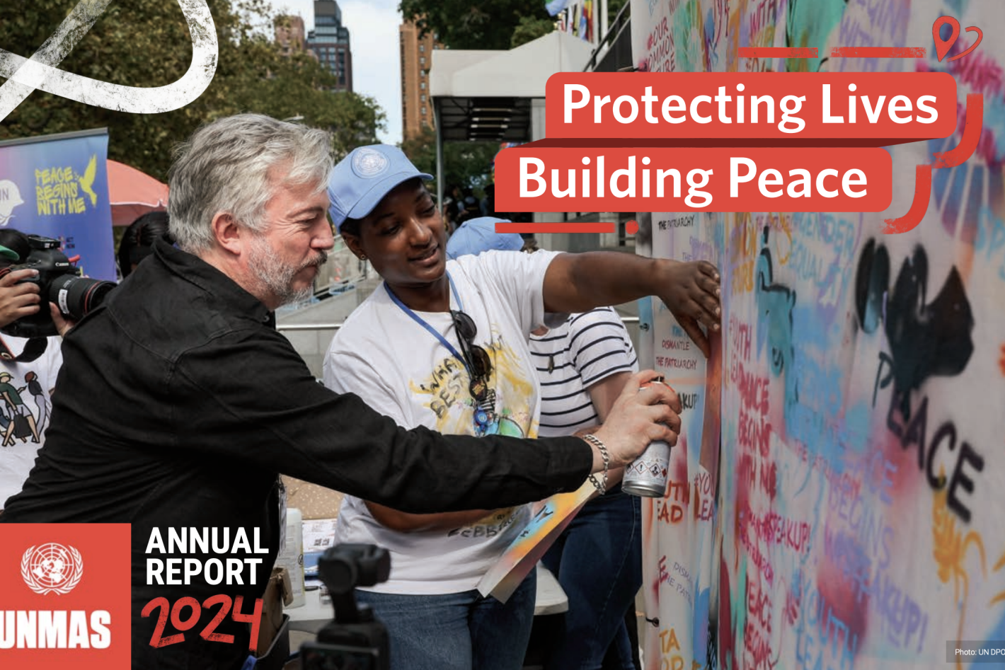 a man is doing some graffiti with a woman beside him.