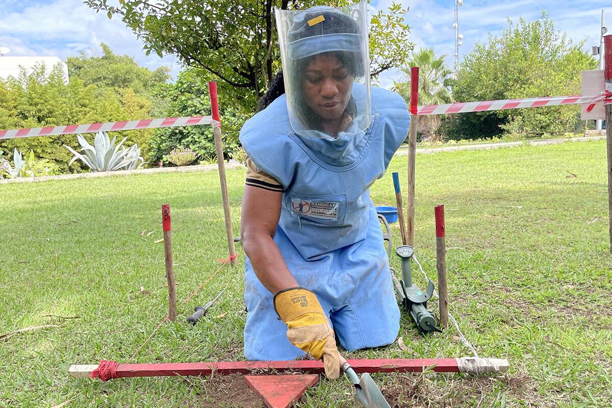 a female deminer is working in a field