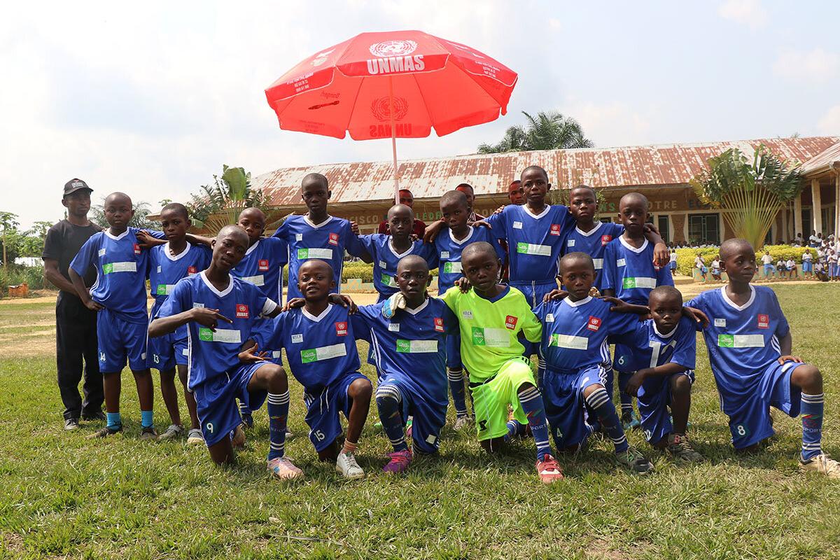 a boy football team under a red umbrella