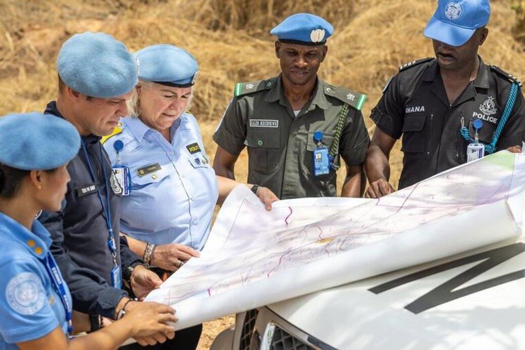Des policiers affectés à la mission de maintien de la paix de l'ONU au Soudan du Sud consultent une carte.