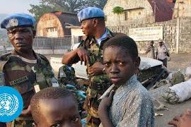 un peacekeepers standing with children