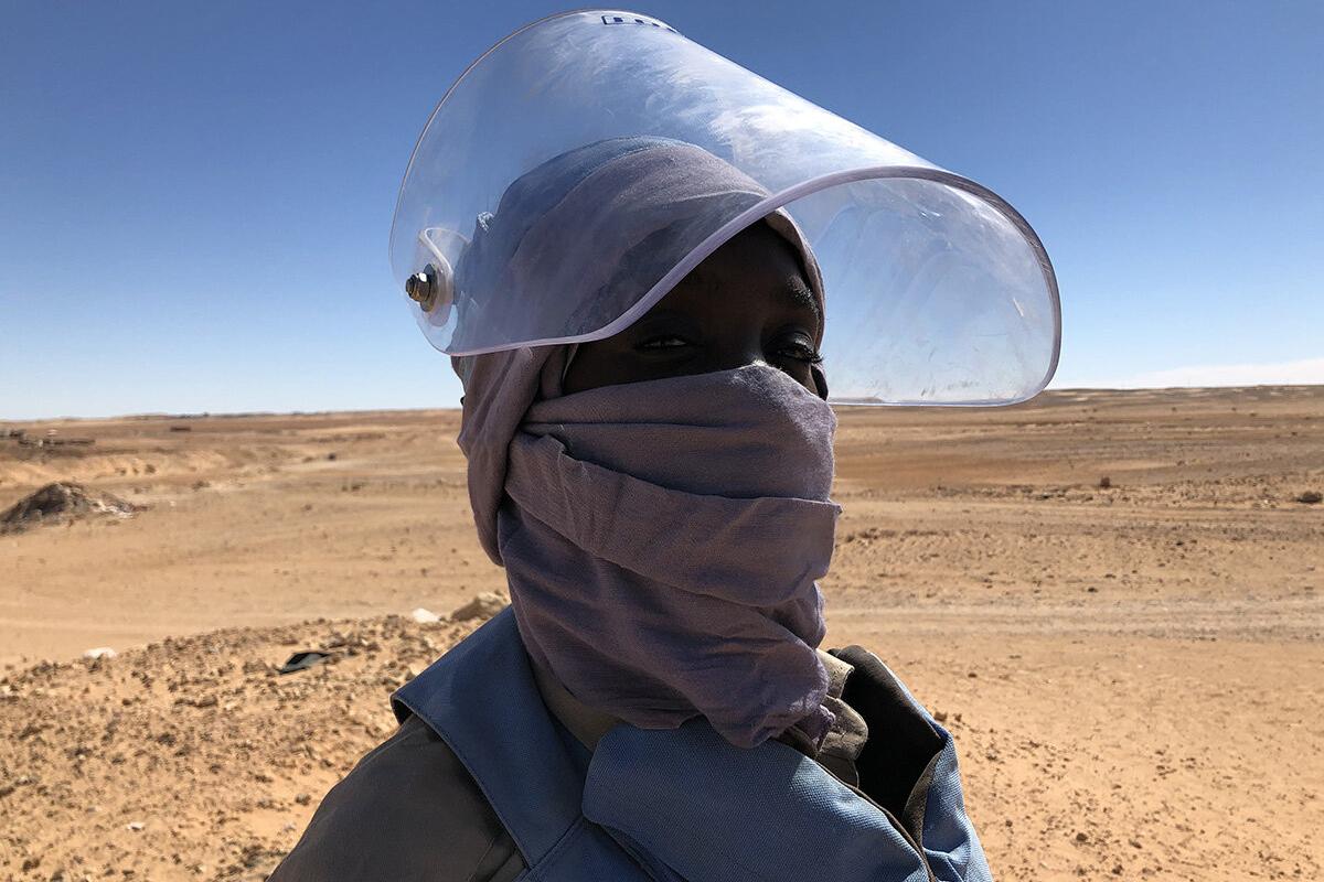 a female deminer with a protective mask