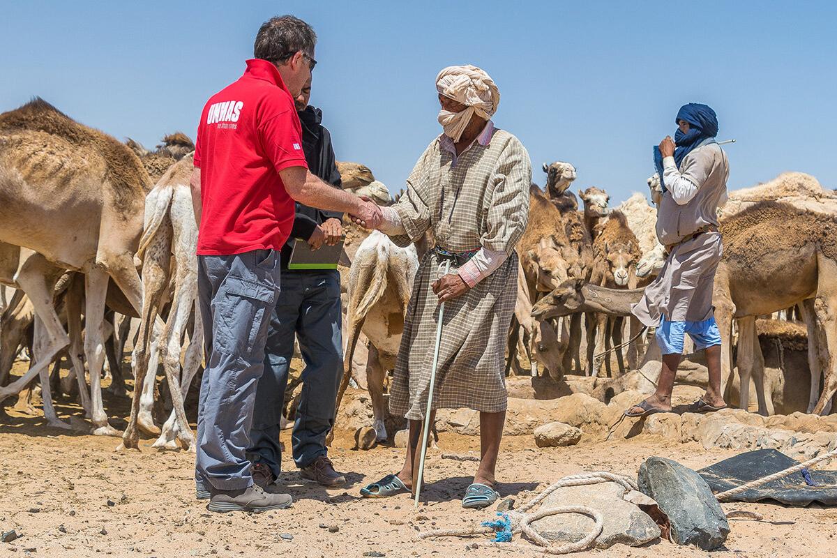 an unmas staff is shaking hand with a villager