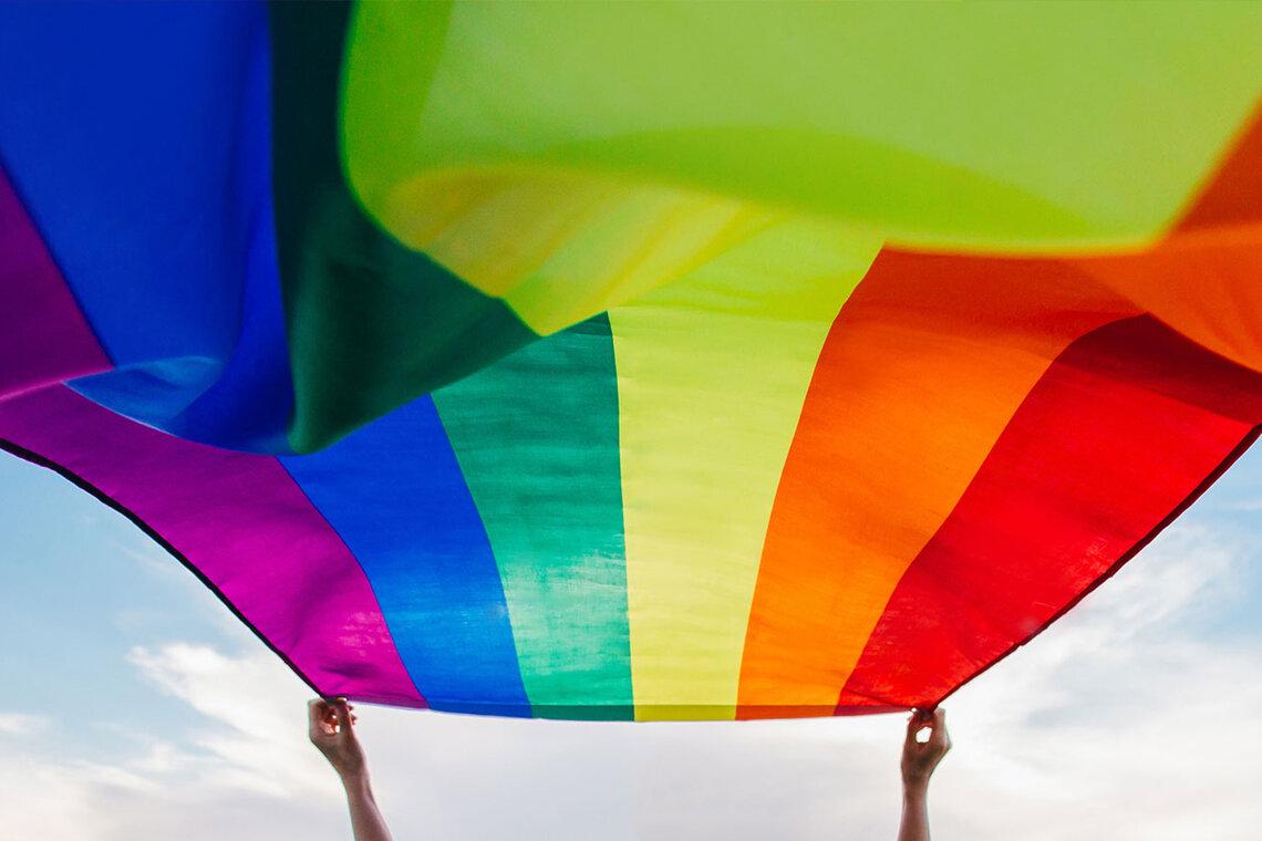 A pride flag flutters in the wind