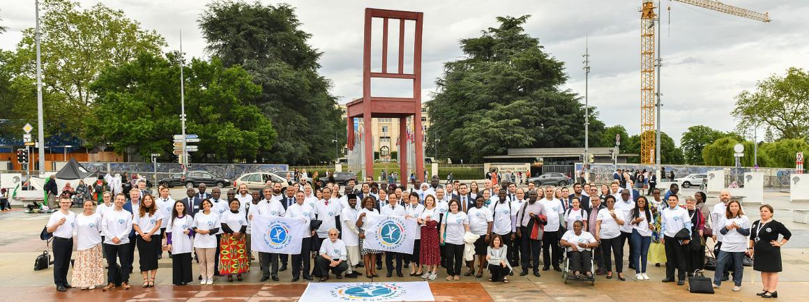 a group of delegates in front of the Broken Chair in Geneva