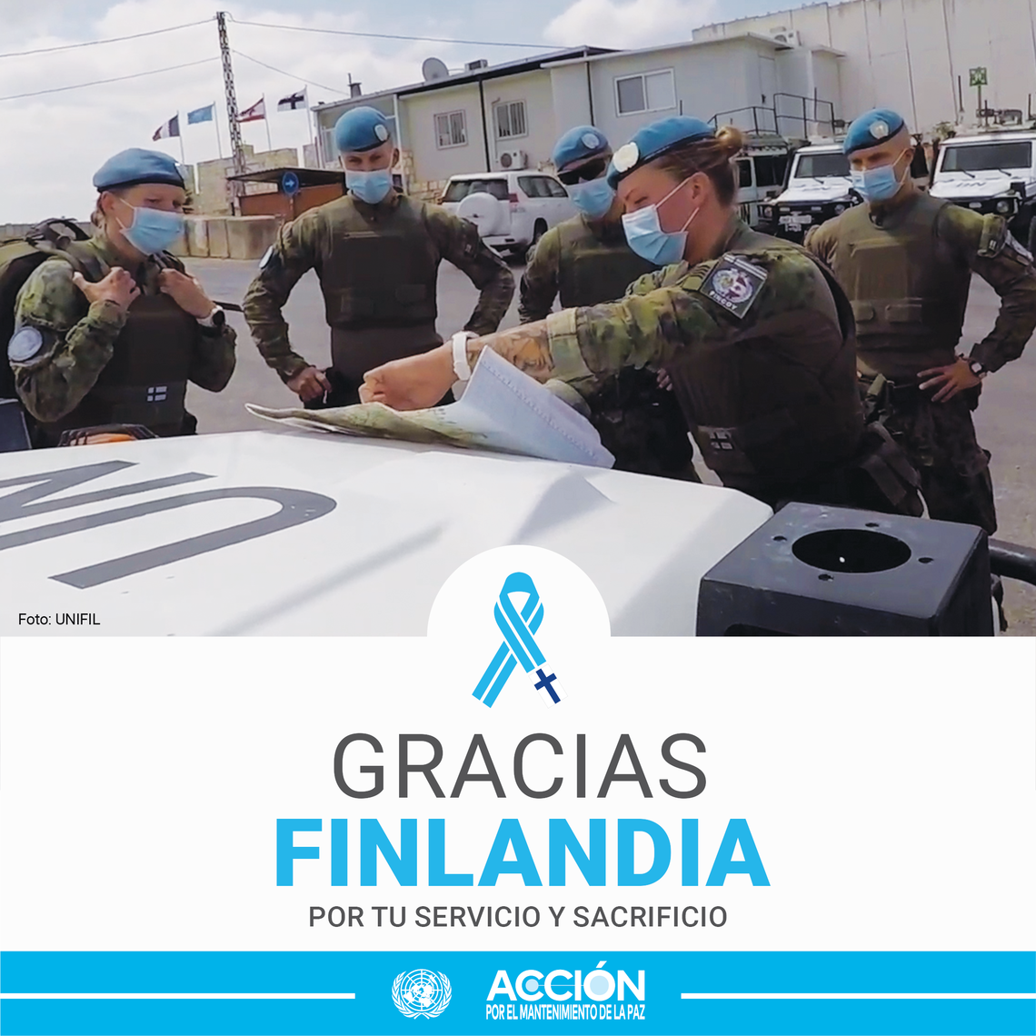 Grupo de cinco cascos azules mirando un mapa al lado de un coche.