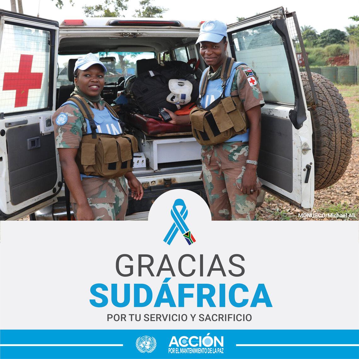 Dos mujeres cascos azules con uniforme de Sudáfrica posando para una foto en la parte trasera de un cuatro por cuatro abierto.