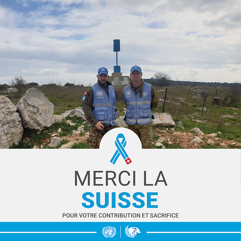 Deux Casques bleus posent pour une photo. Sous la photo est marqué "Merci la Suisse pour votre contribution et sacrifice"