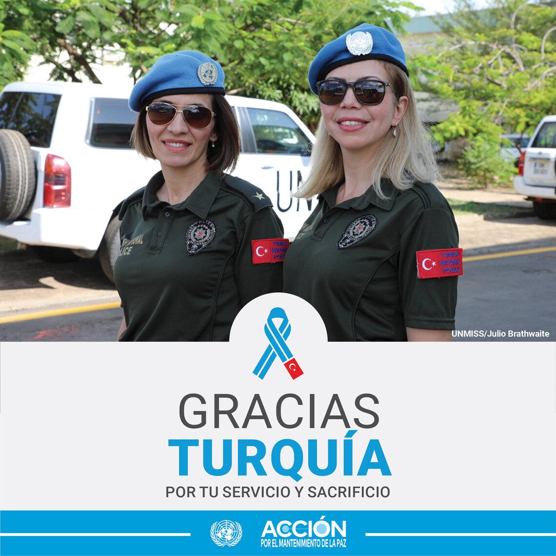 Dos mujeres cascos azules de Turkiye mirando a cámara. De fondo, una furgoneta blanca con el logo de la ONU en la puerta.